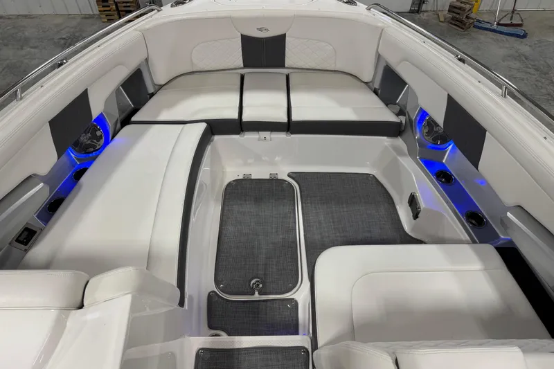 Slide: The Image of 2014 Chaparral 327 SSX boat interior with white seating and blue LED lighting. - 14