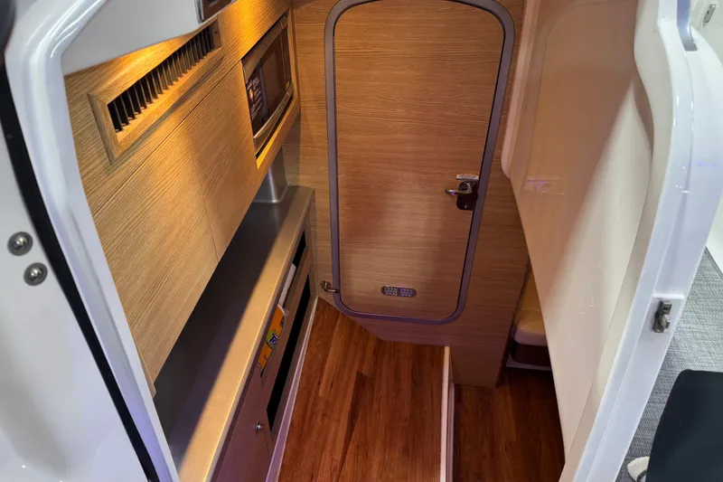Slide: The Image of Interior cabin of 2014 Chaparral 327 SSX boat with wood finish and modern amenities. - 15