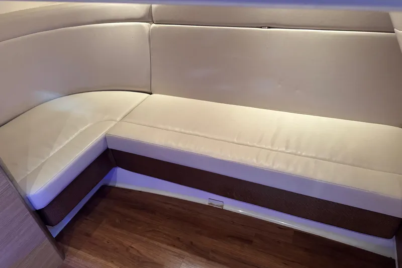 Slide: The Image of 2014 Chaparral 327 SSX interior with beige seating and wooden flooring. - 16