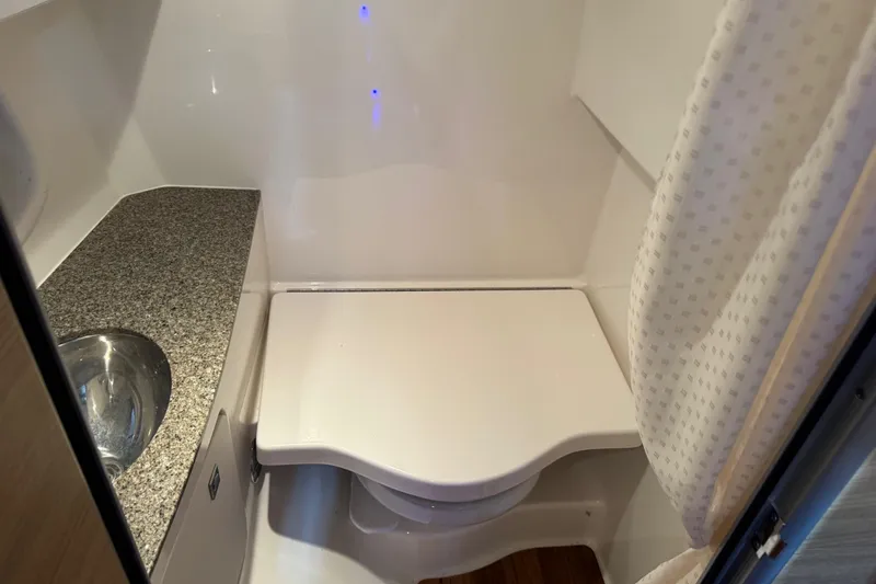 Slide: The Image of 2014 Chaparral 327 SSX boat bathroom with sink and compact toilet. - 17