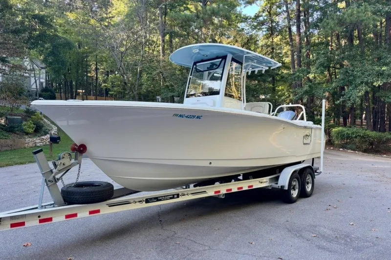 The Image of 2021 Sea Hunt Ultra 255 SE boat on trailer, surrounded by trees. - 1