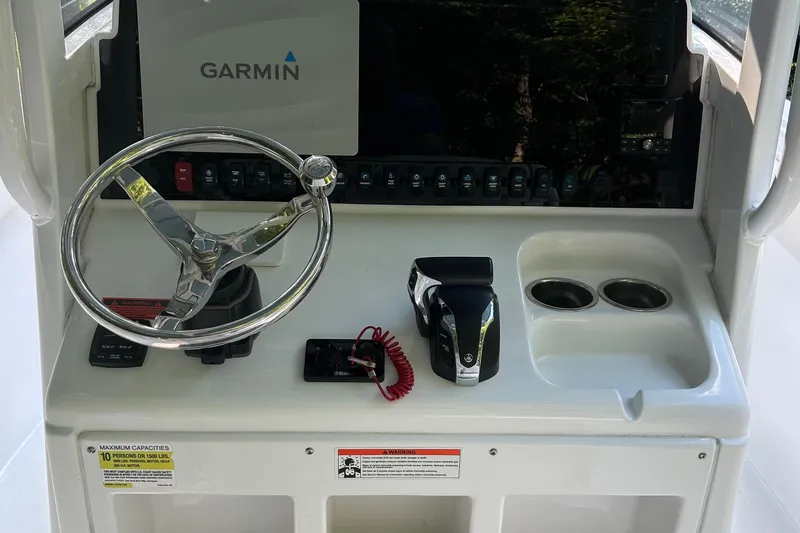 Slide: The Image of 2021 Sea Hunt Ultra 255 SE boat console with Garmin display and steering wheel. - 12