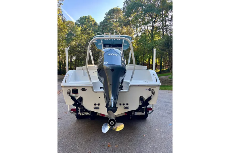 Slide: The Image of 2021 Sea Hunt Ultra 255 SE boat with powerful outboard motor, parked on a driveway. - 6