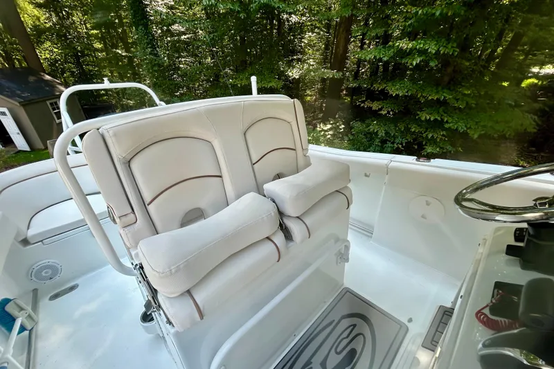 Slide: The Image of 2021 Sea Hunt Ultra 255 SE boat interior with white seating and steering wheel. - 7