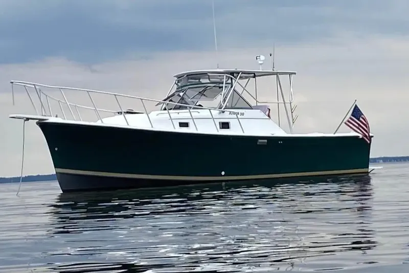 Slide: The Image of 1987 Luhrs 30 Alura Classic boat on calm water with American flag. - 1