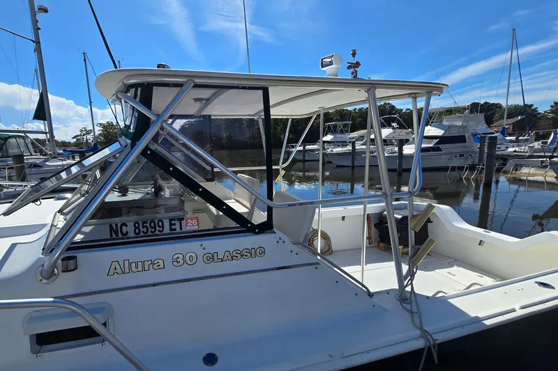 Slide: The Image of 1987 Luhrs 30 Alura Classic boat docked at marina under clear blue sky. - 10