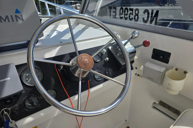 Slide: The Image of 1987 Luhrs 30 Alura Classic boat helm with steering wheel and controls. - 12