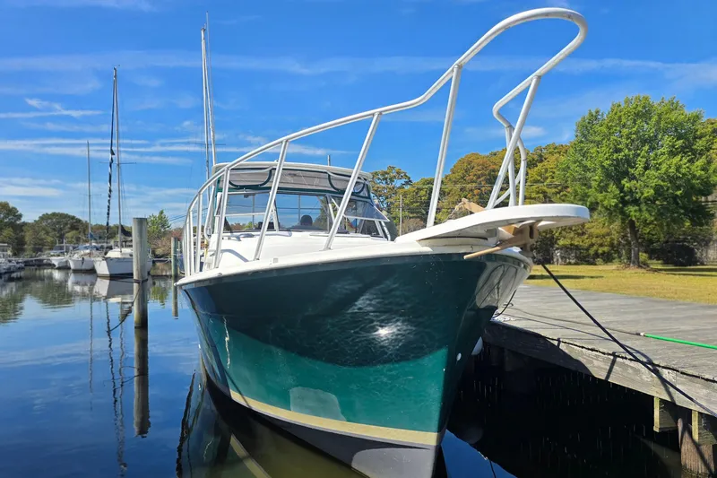 Slide: The Image of 1987 Luhrs 30 Alura Classic boat docked on a sunny day, reflecting in calm water. - 2