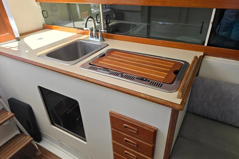 Slide: The Image of 1987 Luhrs 30 Alura Classic boat kitchen with sink, stove, and wooden countertop. - 20