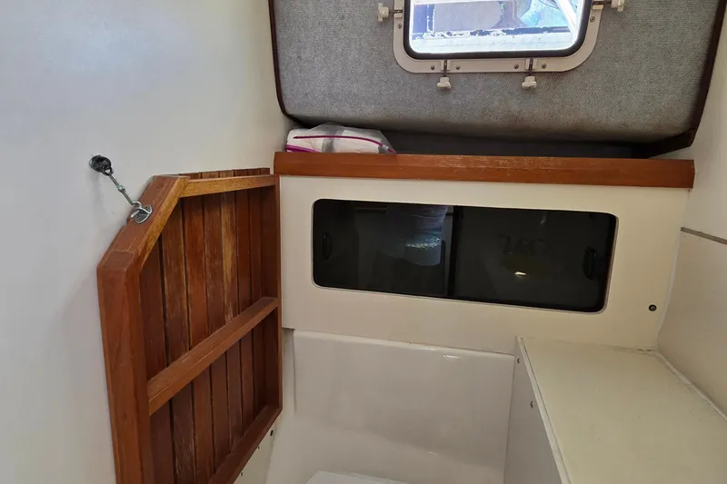 Slide: The Image of 1987 Luhrs 30 Alura Classic cabin interior with wooden accents and storage. - 21