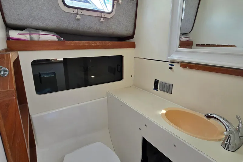 Slide: The Image of 1987 Luhrs 30 Alura Classic boat bathroom with sink, mirror, and window. - 22