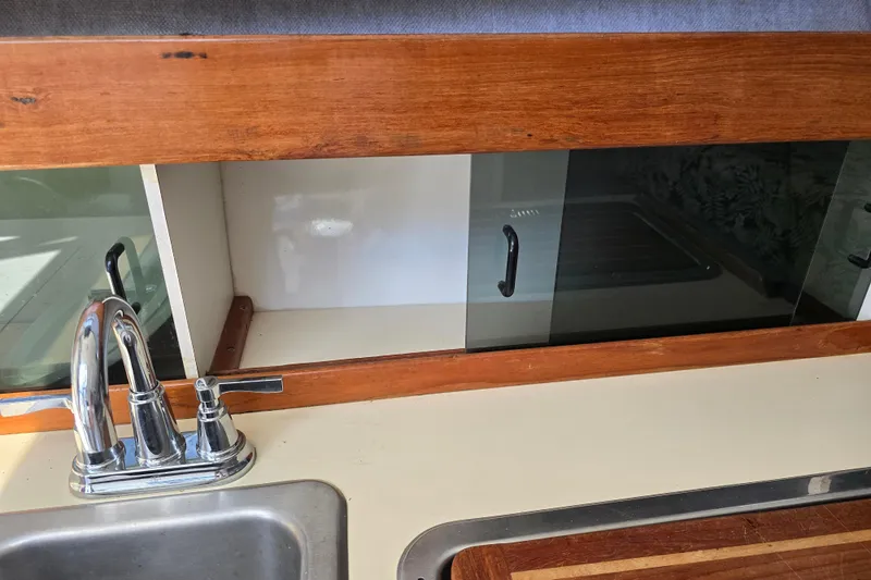 Slide: The Image of 1987 Luhrs 30 Alura Classic boat kitchen with sink and wooden cabinetry. - 24