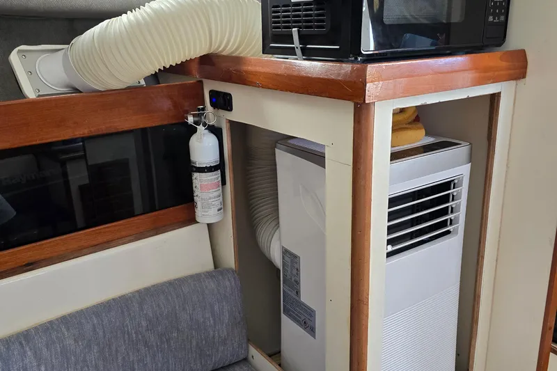 Slide: The Image of 1987 Luhrs 30 Alura Classic interior with air conditioner and microwave setup. - 25