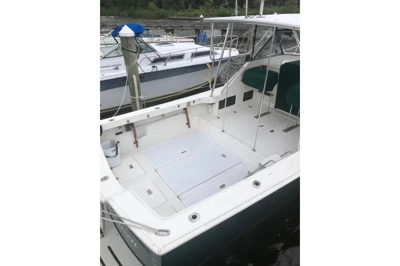 Slide: The Image of 1987 Luhrs 30 Alura Classic boat docked, featuring spacious deck and seating area. - 35