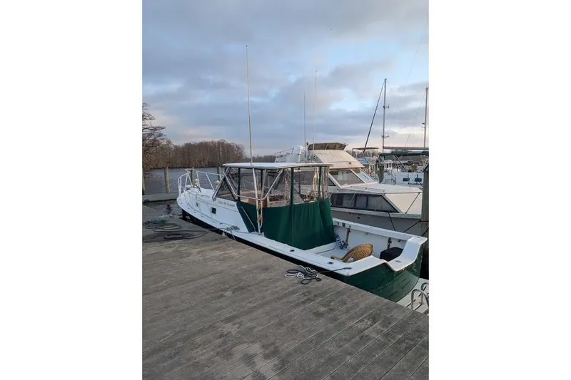 Slide: The Image of 1987 Luhrs 30 Alura Classic boat docked at marina, overcast sky. - 4