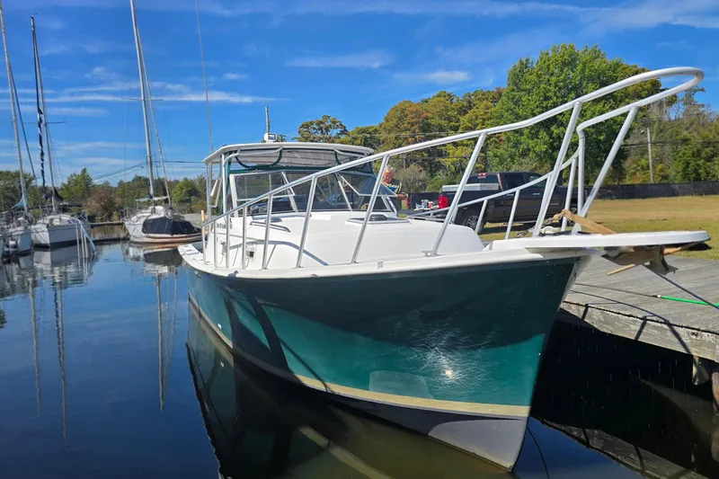 Slide: The Image of 1987 Luhrs 30 Alura Classic boat docked in a serene marina setting. - 5