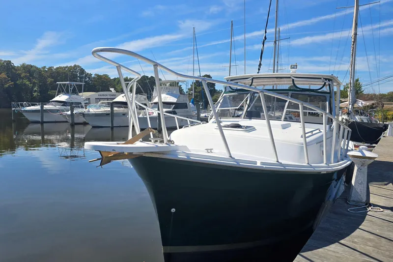 Slide: The Image of 1987 Luhrs 30 Alura Classic boat docked at a marina under clear blue skies. - 6