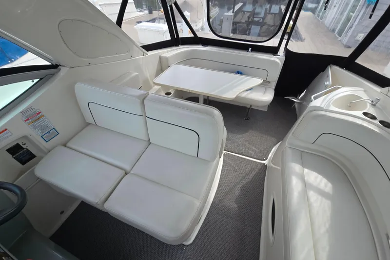 Slide: The Image of Interior of 2011 Bayliner 285 boat with white seating and dining area. - 12