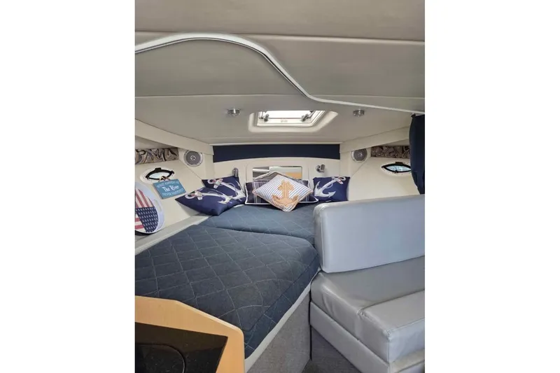 Slide: The Image of Cozy cabin interior of 2011 Bayliner 285 boat with nautical-themed pillows. - 14