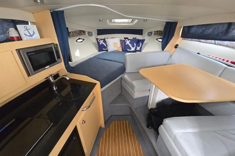 Slide: The Image of Interior of 2011 Bayliner 285 boat with kitchenette, seating, and cozy sleeping area. - 17