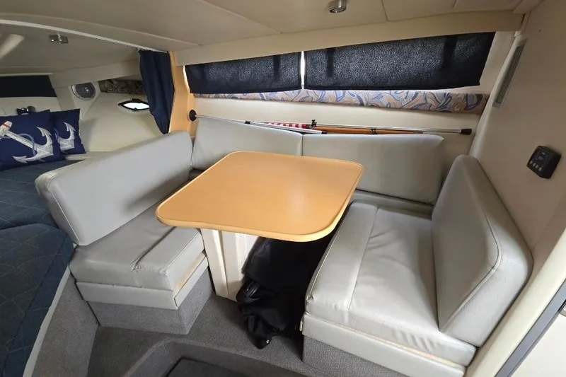 Slide: The Image of Interior of 2011 Bayliner 285 boat with cozy dining area and cushioned seating. - 18