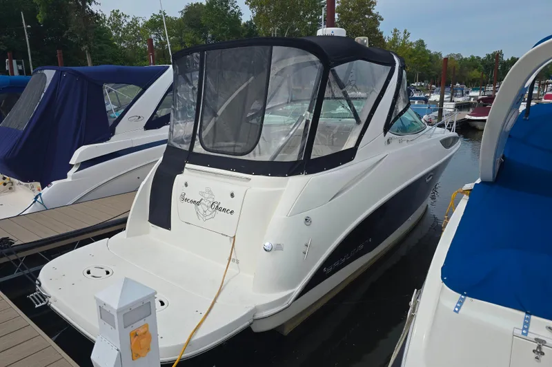 Slide: The Image of 2011 Bayliner 285 boat docked at marina, featuring a covered cockpit. - 4