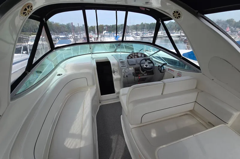 Slide: The Image of 2011 Bayliner 285 boat interior with helm, seating, and marina view. - 9