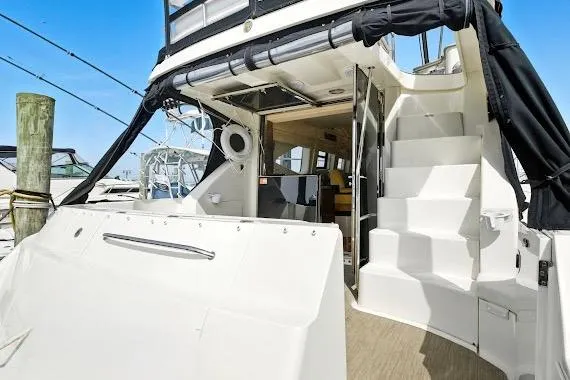 Slide: The Image of 2008 Sea Ray 47 Sedan Bridge yacht with open cabin and stairs, docked at marina. - 11
