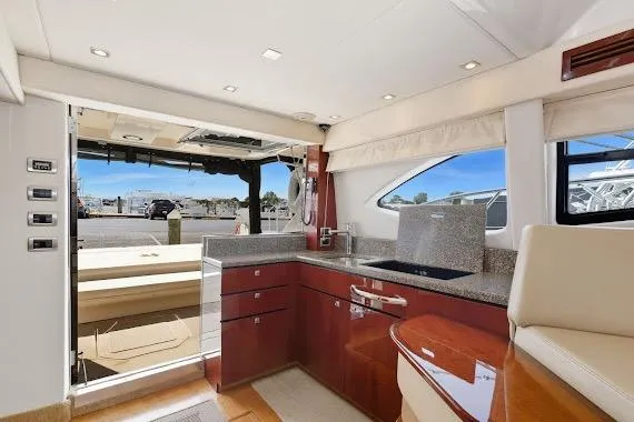 Slide: The Image of 2008 Sea Ray 47 Sedan Bridge yacht interior with modern kitchen and outdoor view. - 21