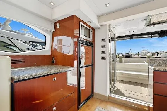 Slide: The Image of Interior of 2008 Sea Ray 47 Sedan Bridge yacht, featuring modern kitchen and outdoor view. - 22