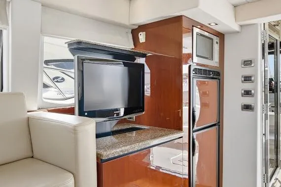 Slide: The Image of Interior of 2008 Sea Ray 47 Sedan Bridge with TV, microwave, and fridge. - 23