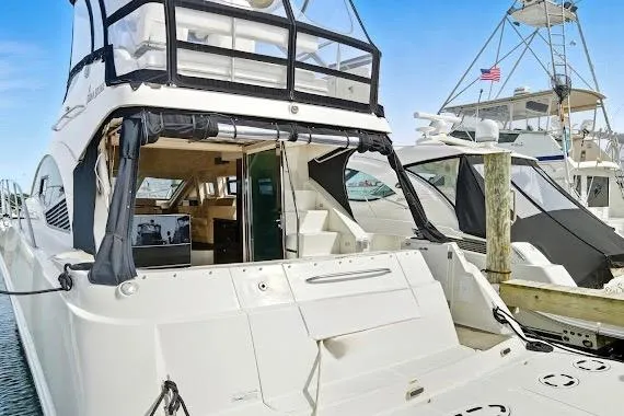 Slide: The Image of 2008 Sea Ray 47 Sedan Bridge yacht docked, showcasing spacious deck and elegant design. - 9