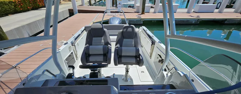 Slide: The Image of 2019 Jeanneau Leader 7.5 CC boat interior with dual seats at dock. - 16