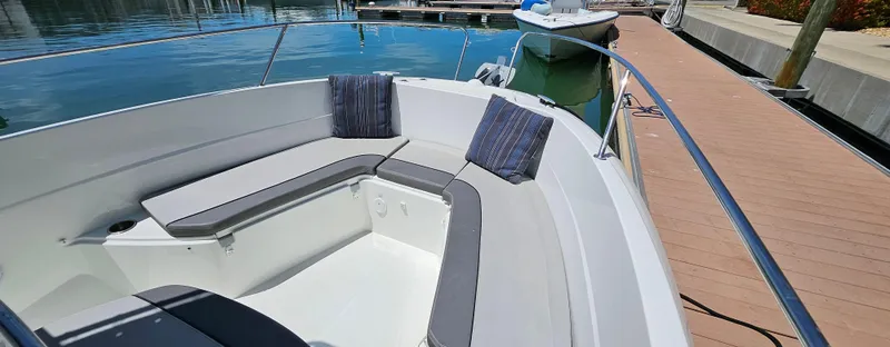 Slide: The Image of 2019 Jeanneau Leader 7.5 CC boat with cushioned seating, docked at marina. - 19