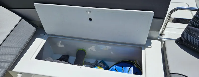 Slide: The Image of Storage compartment on a 2019 Jeanneau Leader 7.5 CC boat, containing various items. - 8