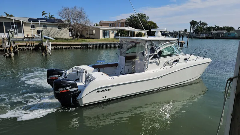 The Image of 2008 World Cat 320 EC boat with dual Suzuki engines on a calm waterway. - 0