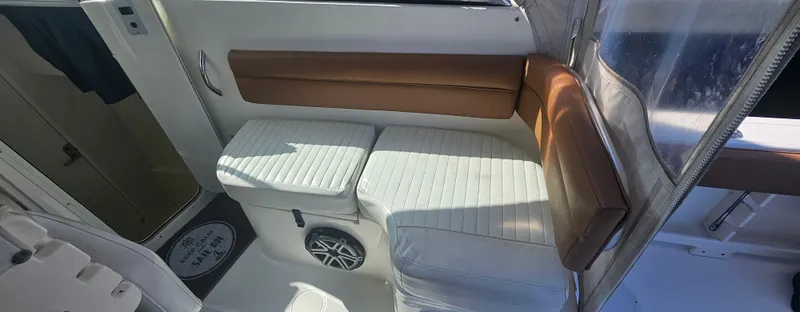 Slide: The Image of 2008 World Cat 320 EC interior seating with white cushions and brown backrest. - 10