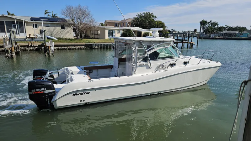 Slide: The Image of 2008 World Cat 320 EC boat with twin Suzuki engines on a calm waterway. - 13