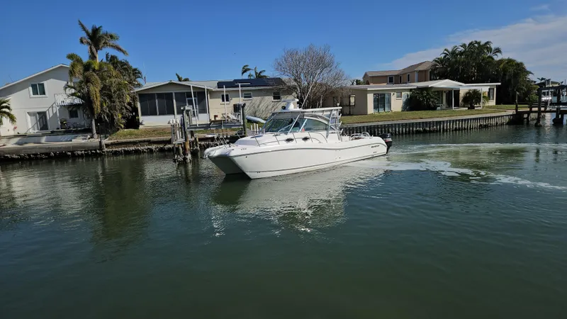 Slide: The Image of 2008 World Cat 320 EC boat cruising near waterfront homes. - 19