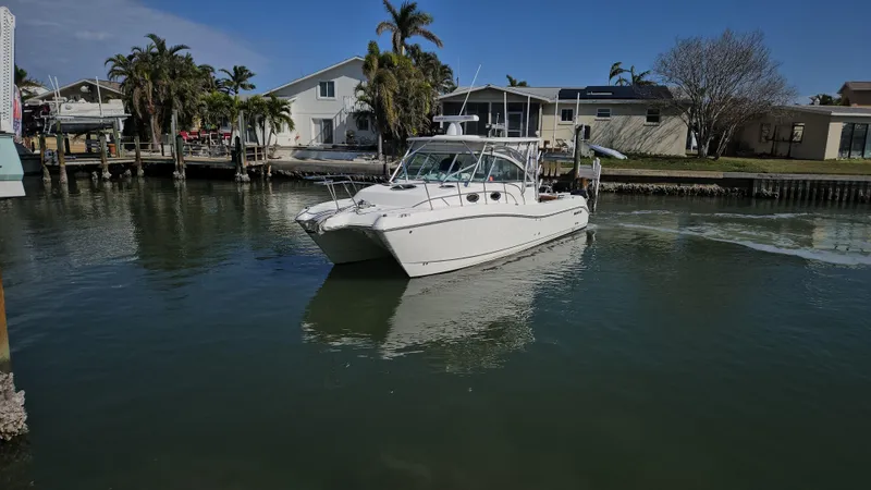 Slide: The Image of 2008 World Cat 320 EC boat cruising in a calm residential canal. - 20
