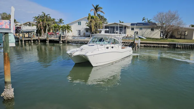 Slide: The Image of 2008 World Cat 320 EC boat docked in a serene residential canal setting. - 21