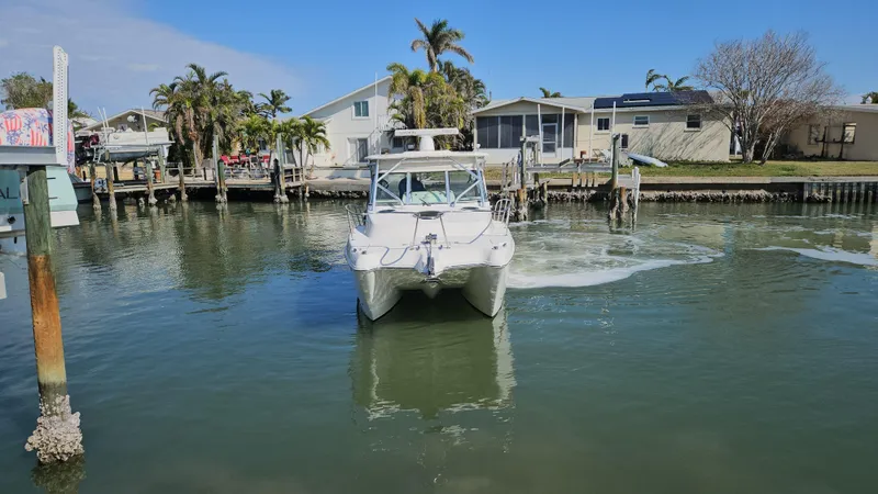 Slide: The Image of 2008 World Cat 320 EC boat docked in a scenic waterfront area. - 22