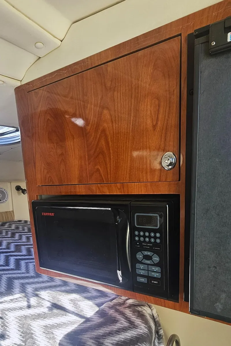 Slide: The Image of 2008 World Cat 320 EC interior with microwave and wooden cabinetry. - 26