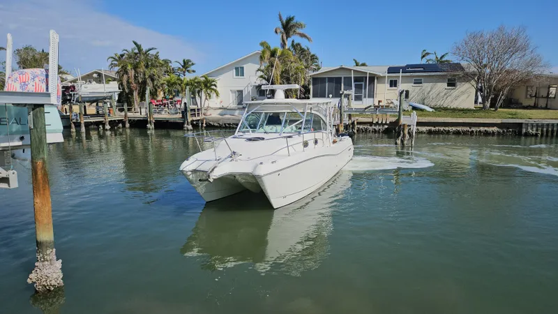 Slide: The Image of 2008 World Cat 320 EC boat navigating a calm residential canal. - 3