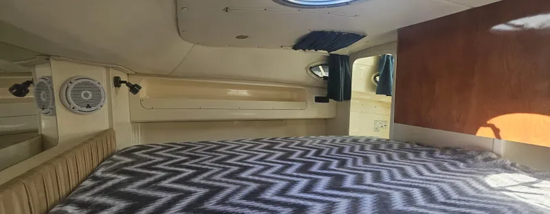Slide: The Image of Interior cabin of 2008 World Cat 320 EC with bed and chevron-patterned blanket. - 4
