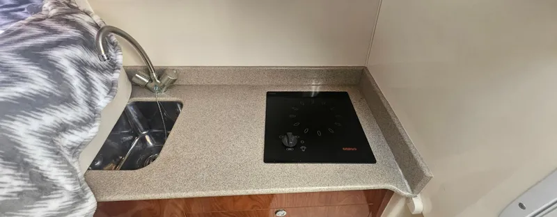 Slide: The Image of 2008 World Cat 320 EC boat kitchen with sink and stovetop. - 5