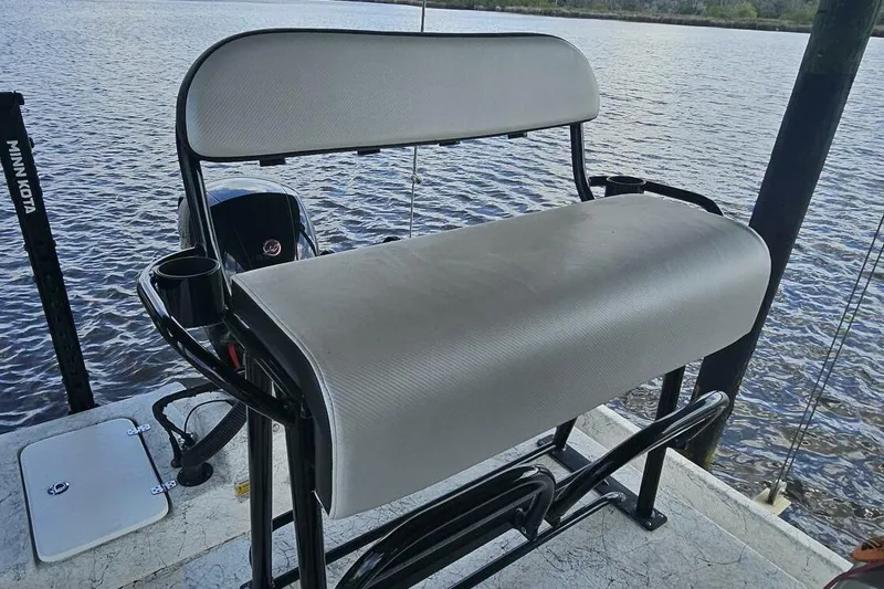 Slide: The Image of 21' Flats Cat boat seat with cup holders, overlooking calm water. - 16