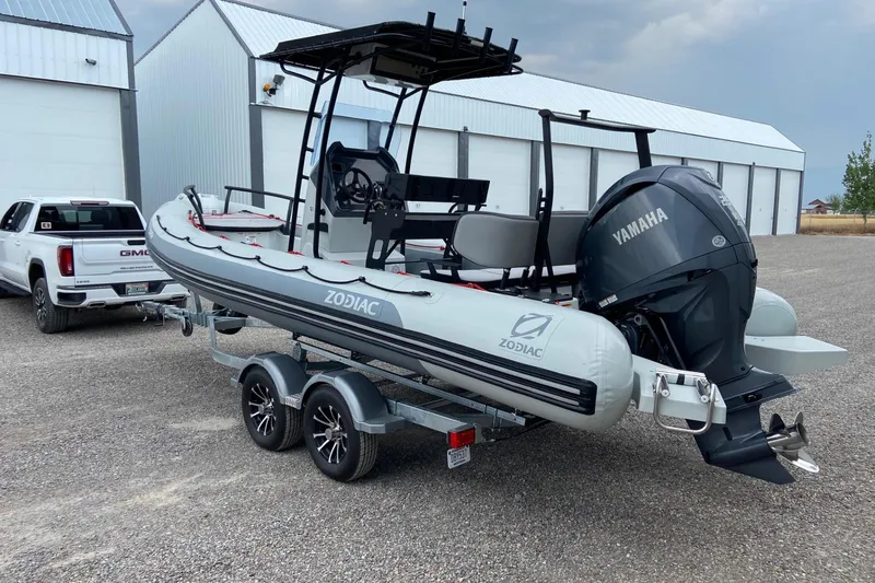 Slide: The Image of 2023 Zodiac Pro Open boat on trailer with Yamaha engine, parked near a white truck. - 6