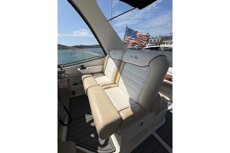 Slide: The Image of 2012 Sea Ray 330 Sundancer boat interior with beige seating and American flag in background. - 15