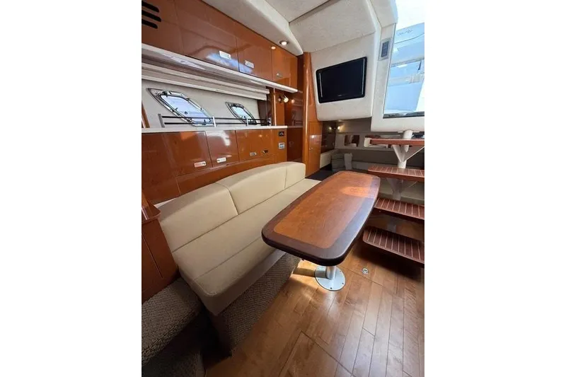 Slide: The Image of Interior of 2012 Sea Ray 330 Sundancer yacht with elegant seating and wooden table. - 20